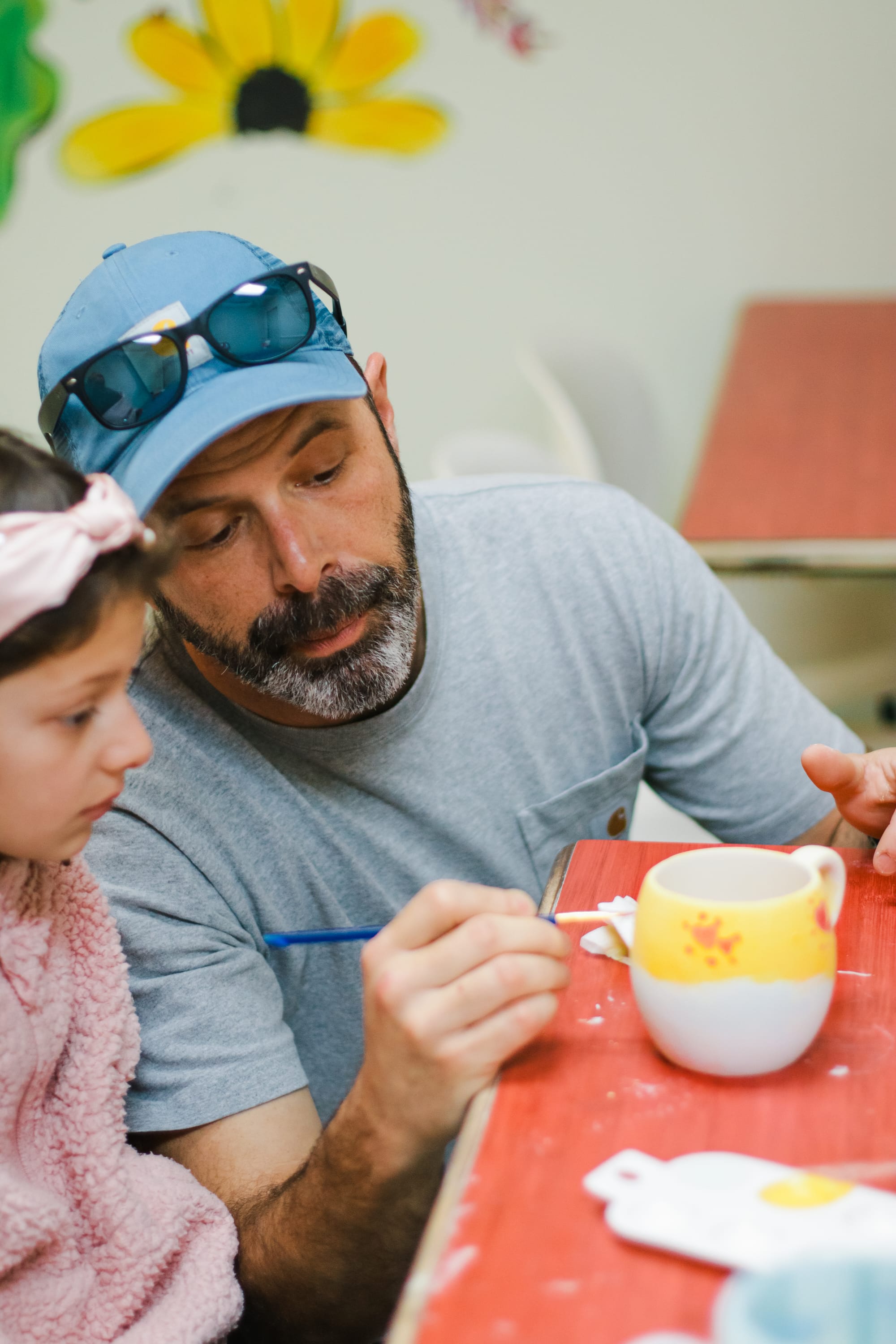 Father and daughter painting a ceramic piece together