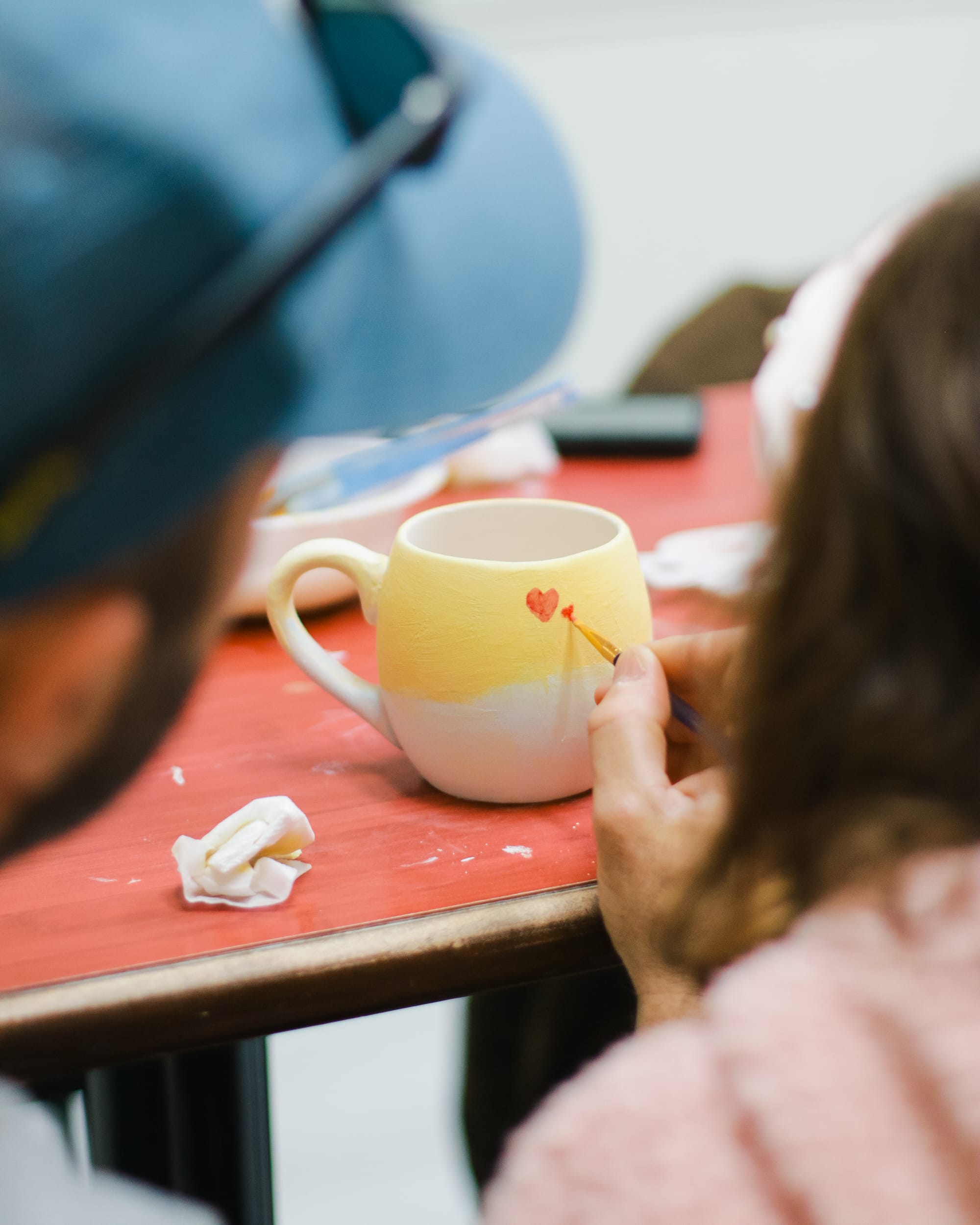 Father and daughter painting heart-shaped pottery