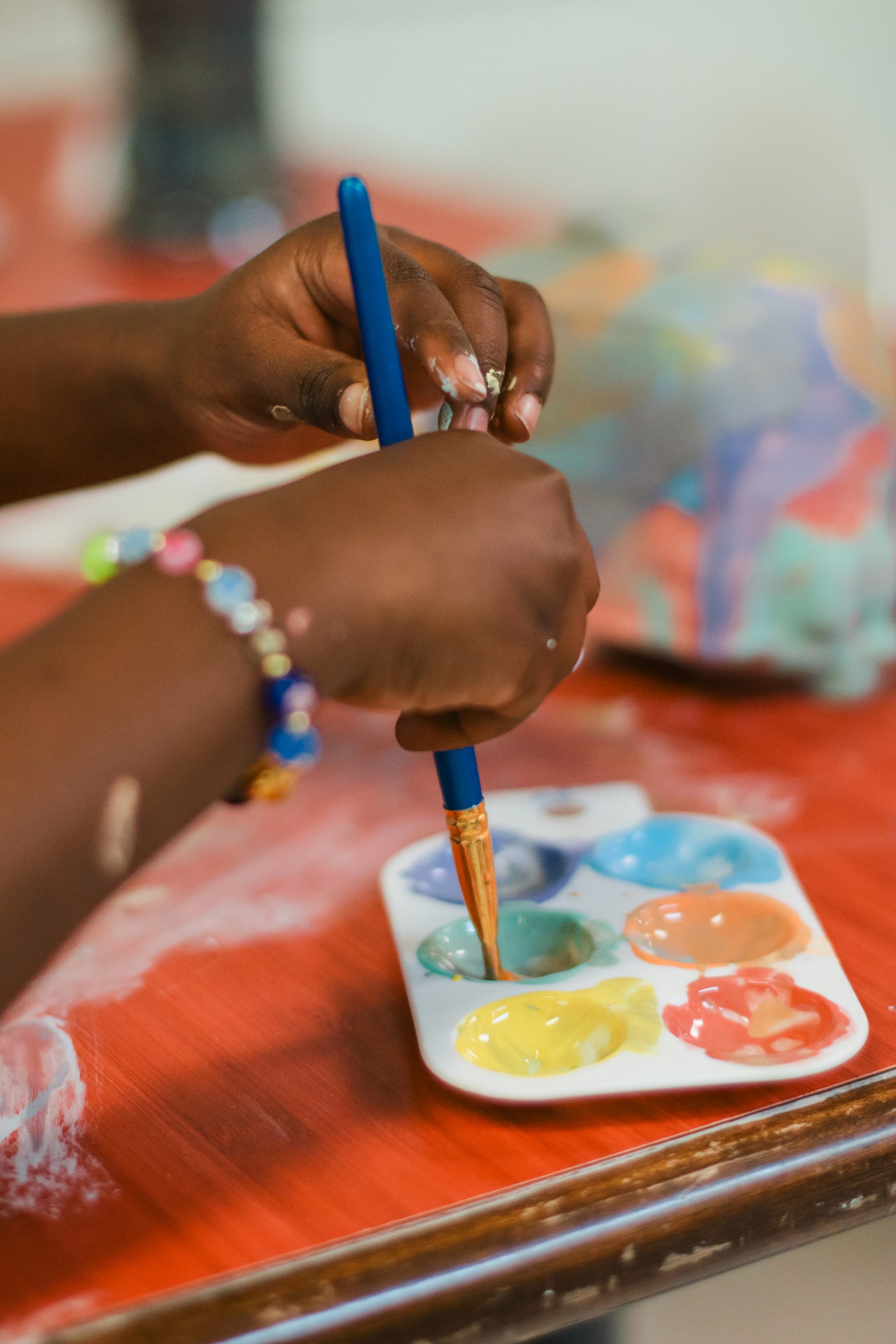 Little kid's hands joyfully painting a ceramic piece
